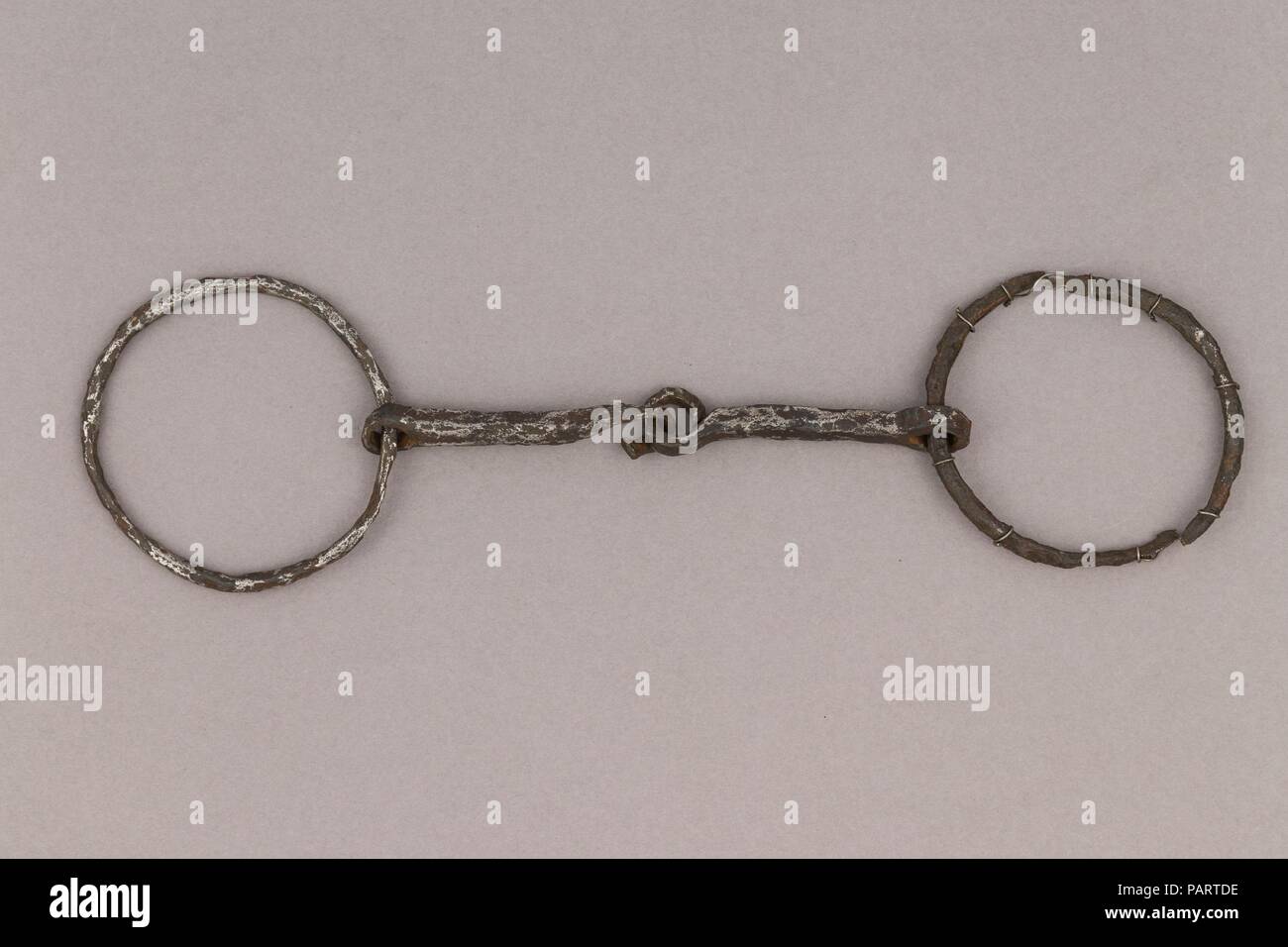 Snaffle Bit. Culture: German. Dimensions: W. 6 1/2 in. (16.5 cm); Wt. 4.8 oz. (136.1 g). Date: 9th-11th century.  If the Vikings are mostly known for being talented sailors, one may forget they were also horse riders, and as in all the Germanic cultures, horses had great importance in their society, in both its social and religious aspects. Equestrian equipment, like stirrups, spurs and bits, are regularly found in Viking burials, among the goods warriors wanted to bring with them to the afterlife. The elite would sometimes even be accompanied by sacrificed horses, a meaningful practice at tha Stock Photo