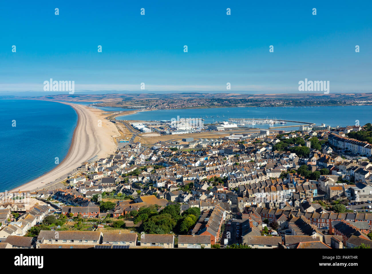 Portland Dorset England July 24, 2018 View from Portland Heights overlooking the town of Fortune's Well, showing Chesil Beach, Portland harbour and Th Stock Photo