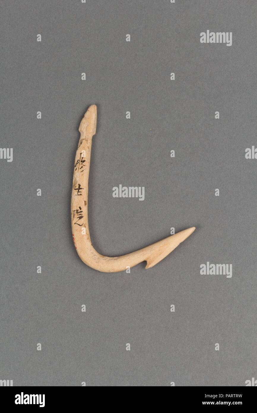 Fishhook. Culture: Japan. Dimensions: W. 1 5/8 in. (4.1 cm); L. 2 3/8 in. (6 cm).  These implements--an arrowhead, fishhooks, needle, and harpoon--were skillfully carved from bone, a material worked by Japanese artisans since Paleolithic times. They were found in the Obara Shell Mound at Ofunato Bay in Iwate Prefecture. According to information gleaned from shell mounds, or middens, the people of the Jomon period relied on a variety of strategies to obtain food. The large number of fishhooks, fashioned with and without barbs, together with the rich array of marine remains found in these rubbis Stock Photo