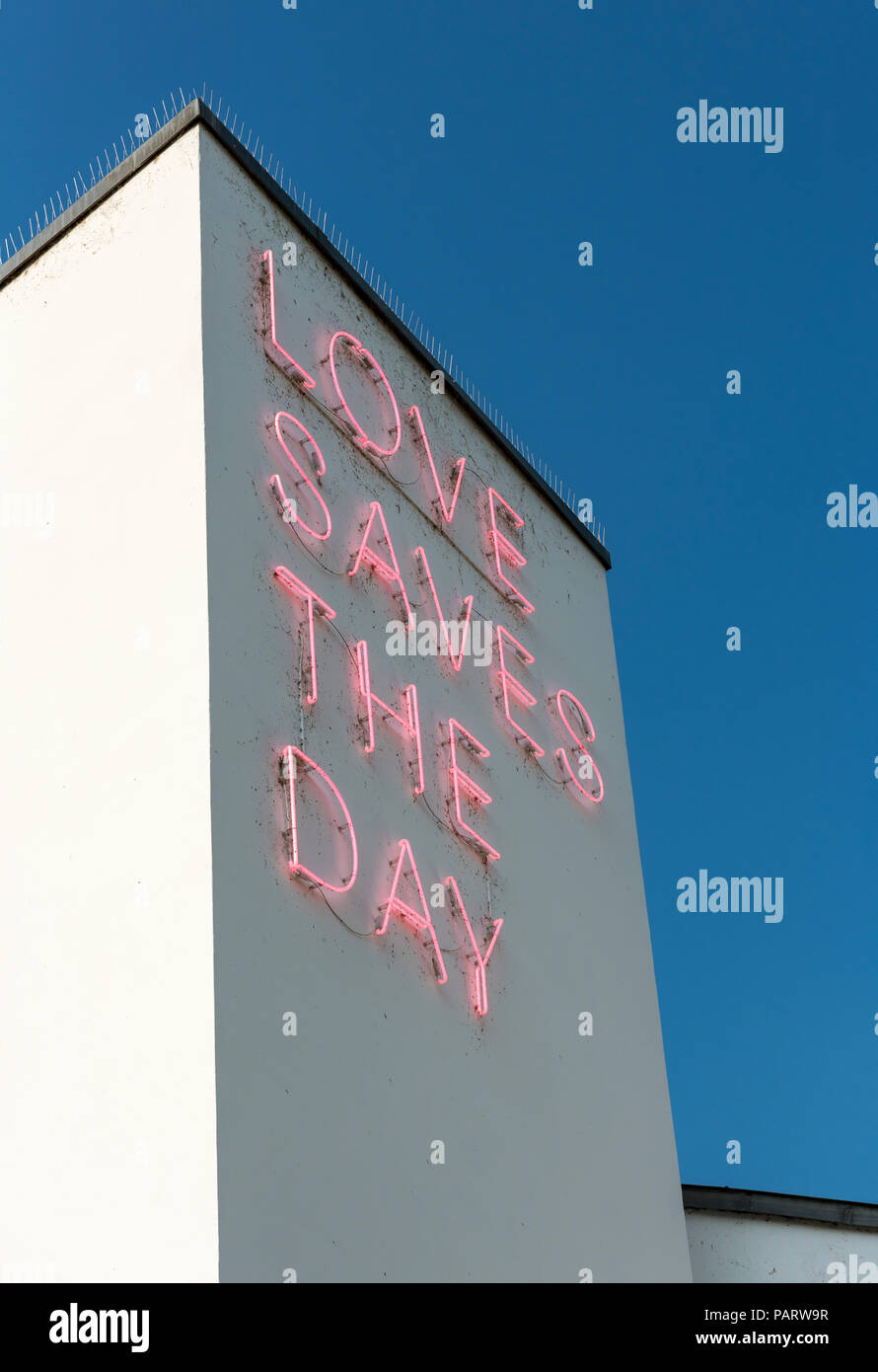 Neon sign Loves Save the Day on facade of Vitra Design Museum building in Weil am Rhein, Germany Stock Photo
