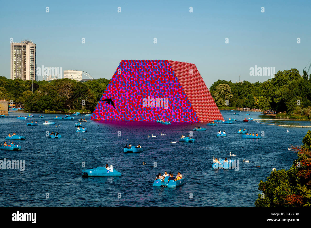 People In Pedal Boats On The Serpentine with ‘The Mastaba’ Floating Sculpture In The Backround, Hyde Park, London, England Stock Photo