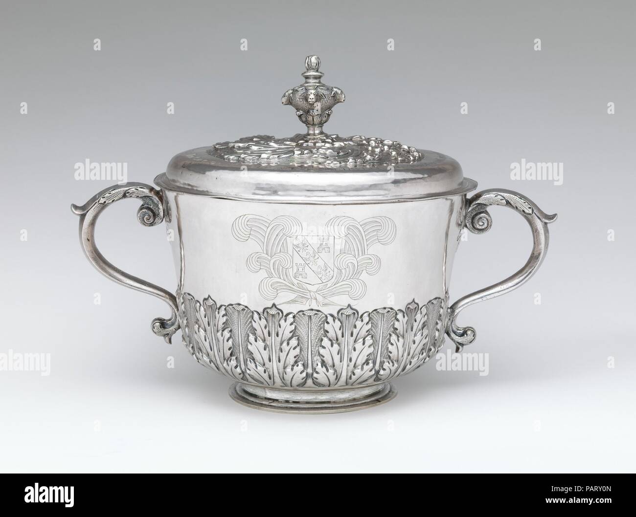 Two-handled cup with cover. Culture: British, London. Dimensions: Overall (confirmed): 9 9/16 x 13 1/2 x 8 7/8 in. (24.3 x 34.3 x 22.5 cm). Maker: I H (British, mid-late 17th century). Date: 1676/77.  This cup originally was made for use in a private home--perhaps as a 'loving cup'--to be passed among guests or displayed on a sideboard. In 1765, when it would have seemed distinctly old fashioned, it was bequeathed to the Church of Charing, where it was used as a communion cup. The donor, Elizabeth Ludwell, had her coat of arms engraved on the side and an inscription added to the cover. Museum: Stock Photo