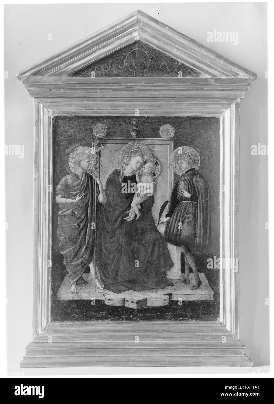 Madonna and Child Enthroned with Saint John the Baptist and Another Saint. Artist: Italian (Florentine) Painter (second quarter 15th century). Dimensions: Overall, with engaged frame, 29 3/4 x 17 1/8 in. (75.6 x 43.5 cm); painted surface 17 1/8 x 14 1/4 in. (43.5 x 36.2 cm).  Despite its generally poor condition, this is a work of considerable interest. The poses of the Virgin and Child are especially inventive. The picture was at one time attributed to Pesellino, but it has also been thought a Sienese work close to Domenico di Bartolo. It is probably Florentine and dates around 1440. The fram Stock Photo