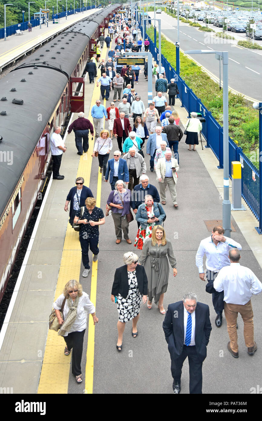 View from above looking down on steam train carriages crowd of people walking to front to see historic locomotive Oxford Parkway railway station UK Stock Photo