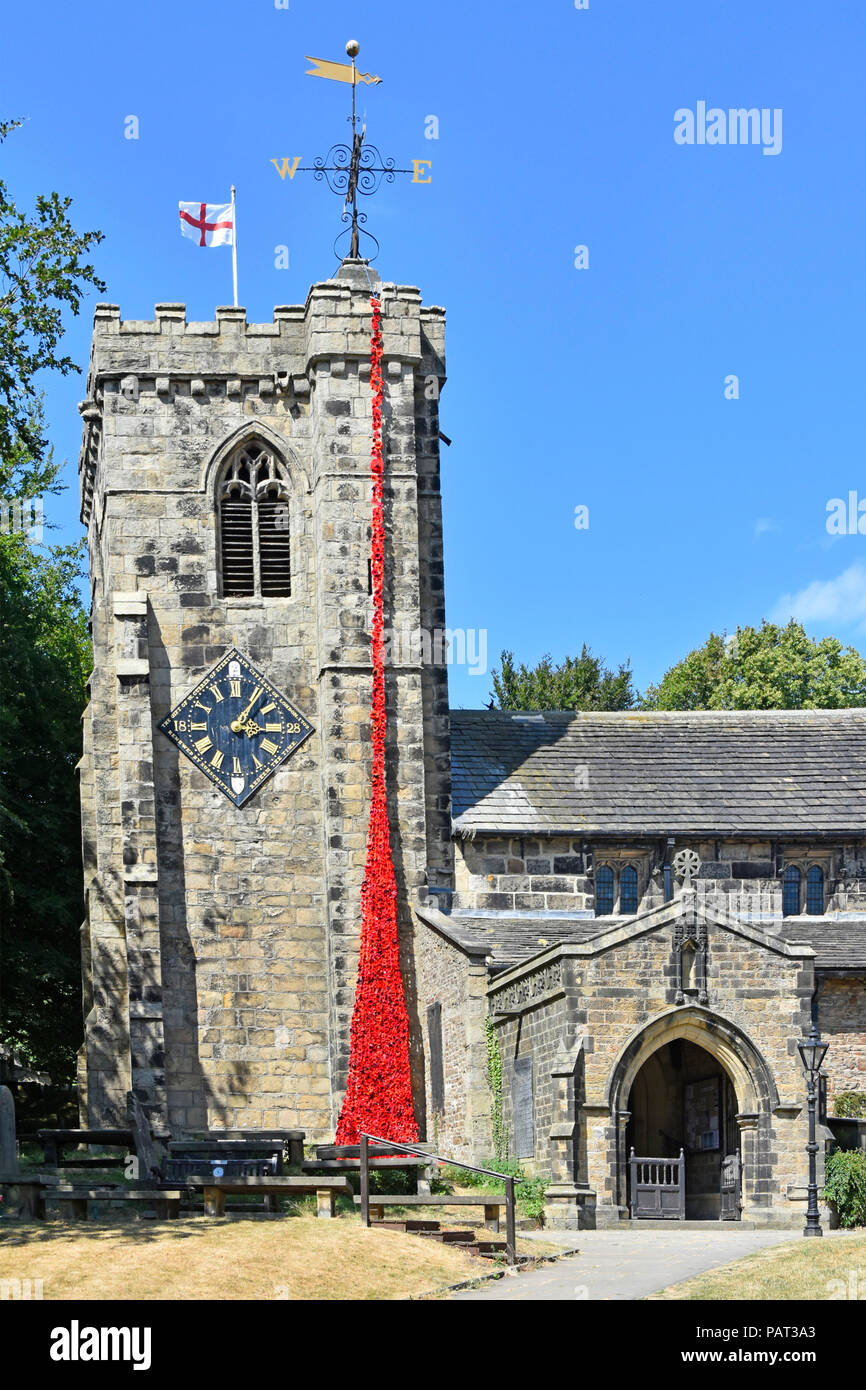 Remembrance end of First World War red poppy cascade made by local school children falls from top St Andrews Church clock tower Kildwick Yorkshire uk Stock Photo