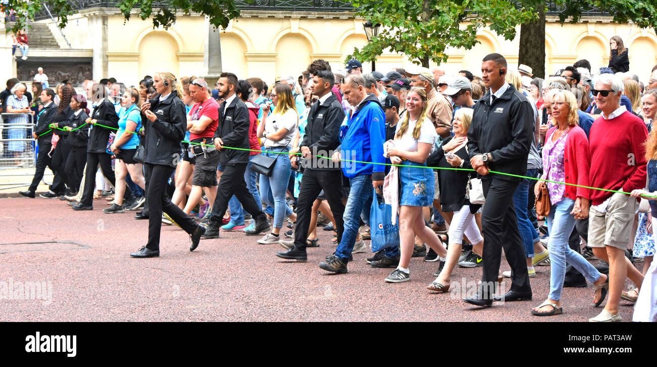 London street scene crowd of people & marshals control group walking The Mall towards Buckingham Palace at RAF centenary parade & flypast England UK Stock Photo