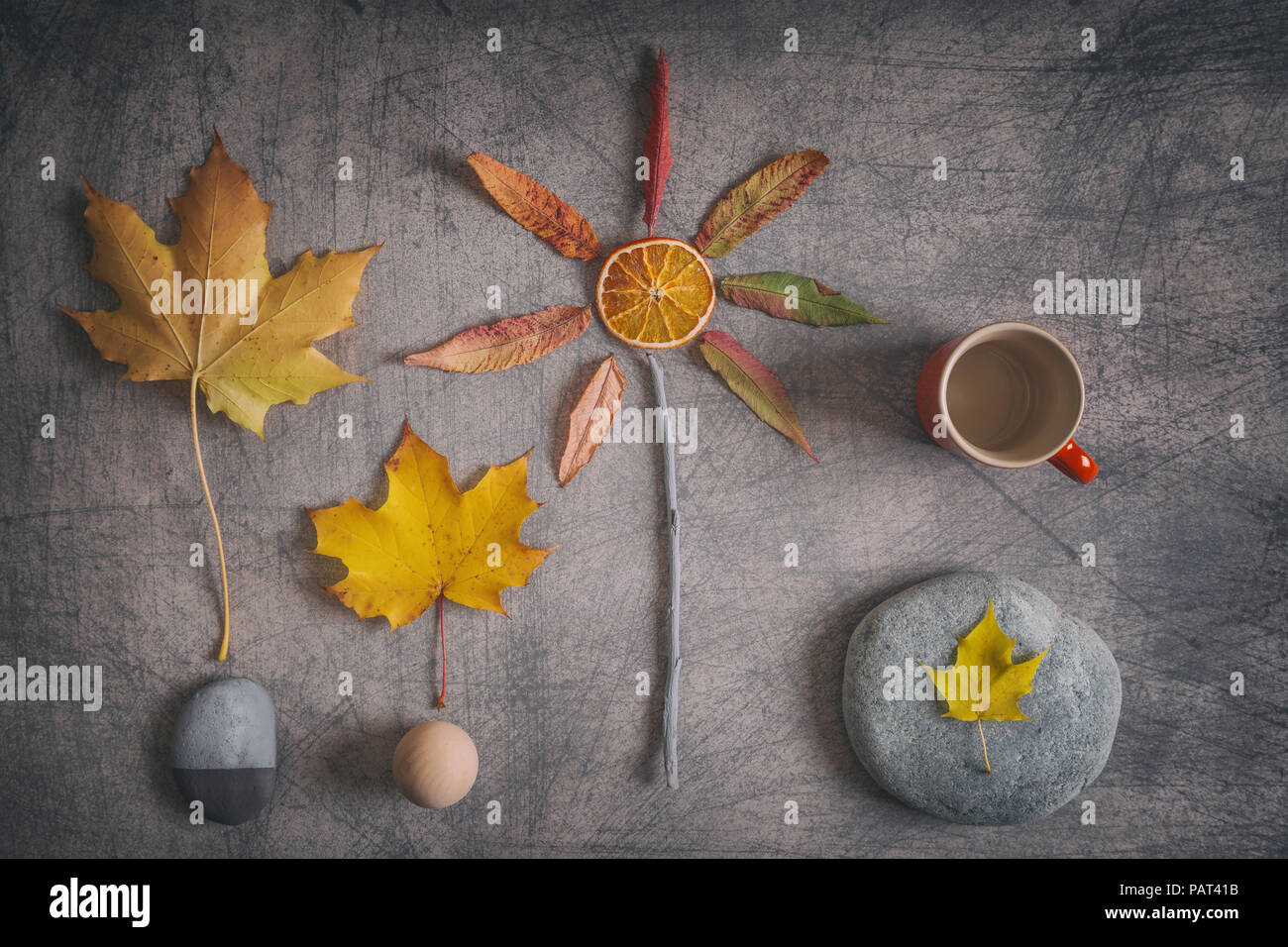Creative autumnal composition made of a few simple objects in warm orange-yellow tones on rustic background Stock Photo