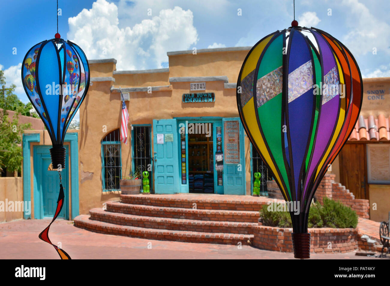 handcrafted paper  art of hot air balloons hang from under potico of shopping district in Old Town Albuquerque, NM across from Aobe Complex of shops a Stock Photo