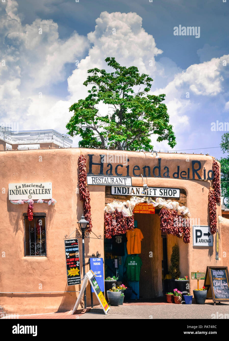 A colorful Entrance to old adobe building, the Hacienda del Rio, an Native American gift shop and restaurant decorated entrance with chii ristas in ol Stock Photo