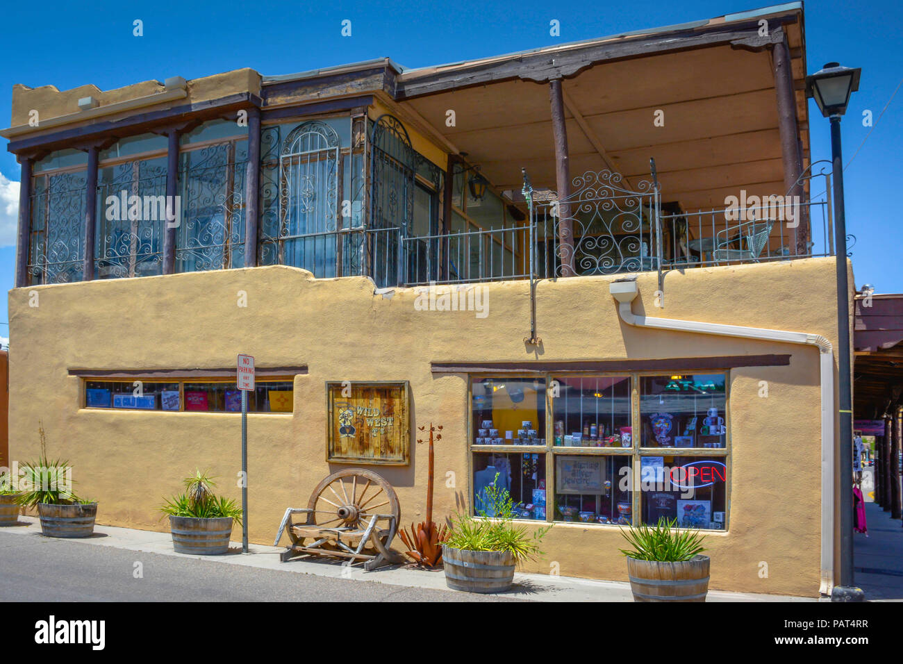 An old and unusual adobe building with a balcony and decorative wrought iron houes the Wild West T's & Gifts  in old town Albuquerque, NM Stock Photo