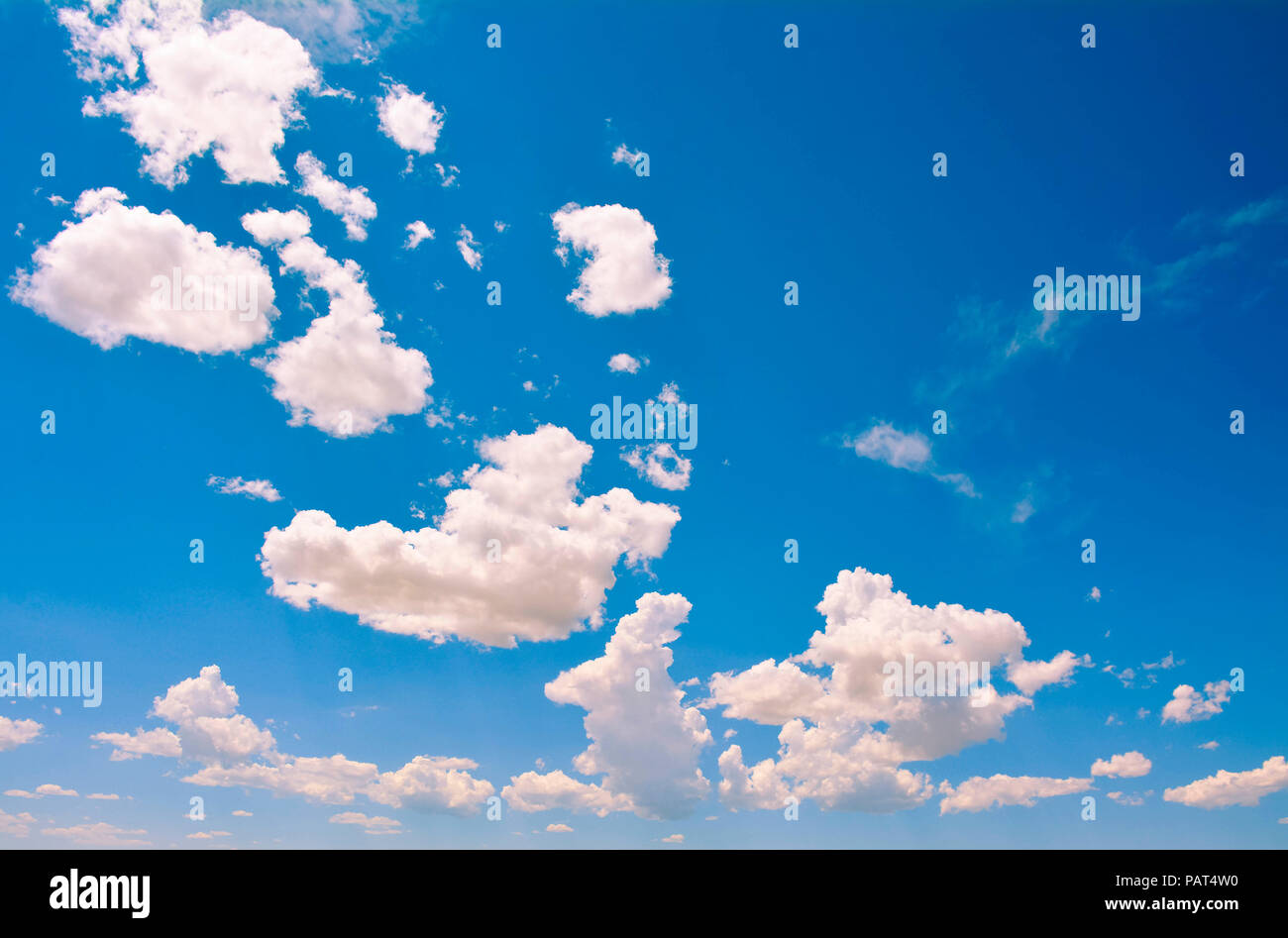 a View the sky's horizon full of distant white fluffy clouds against gradated blue sky Stock Photo