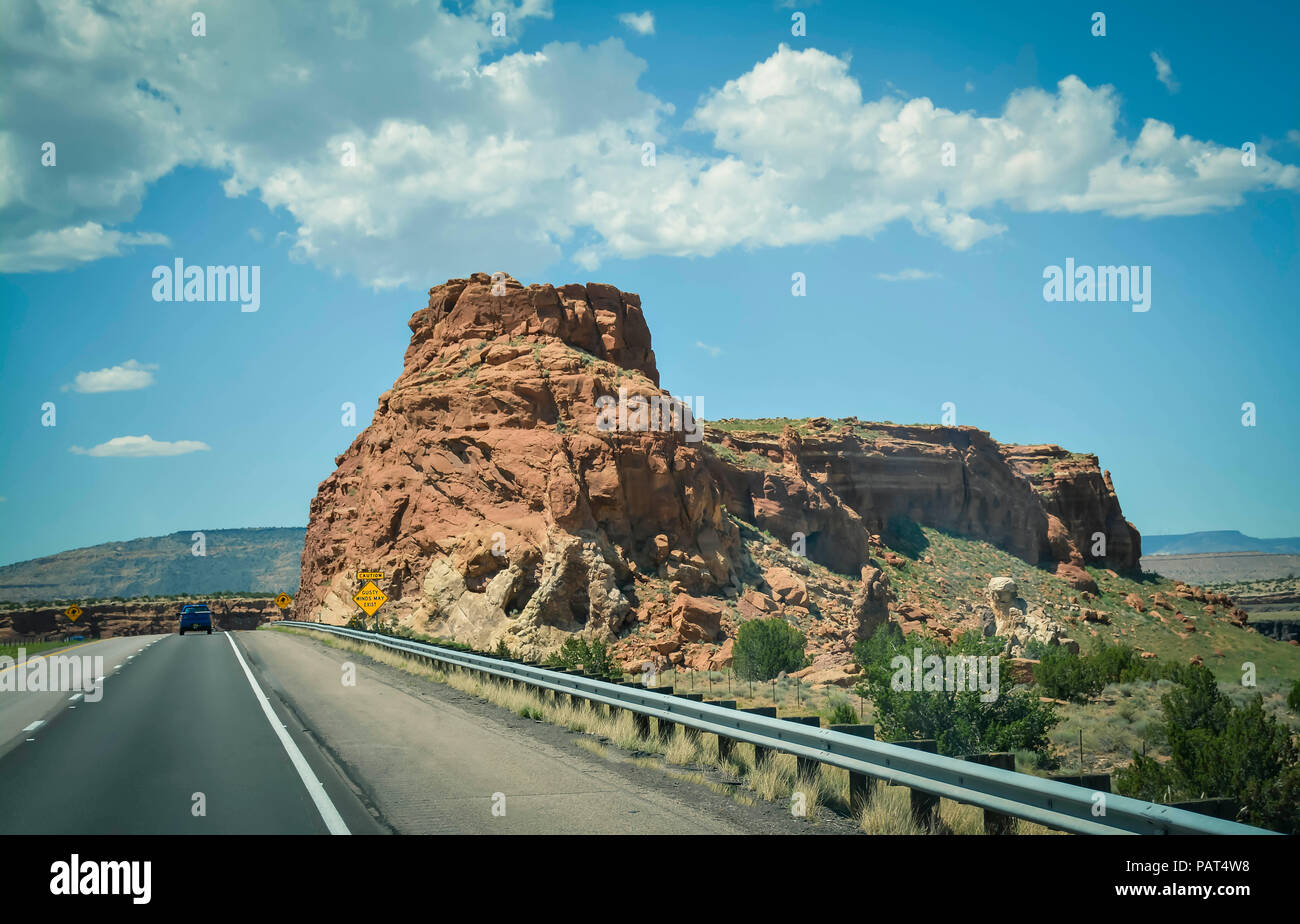Driving Route 66 in NM with views of mesas, buttes and red rock land formations around every turn Stock Photo