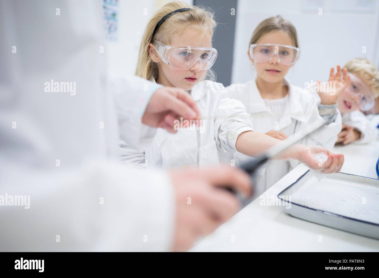 Pupils in science class watching teacher experimenting Stock Photo
