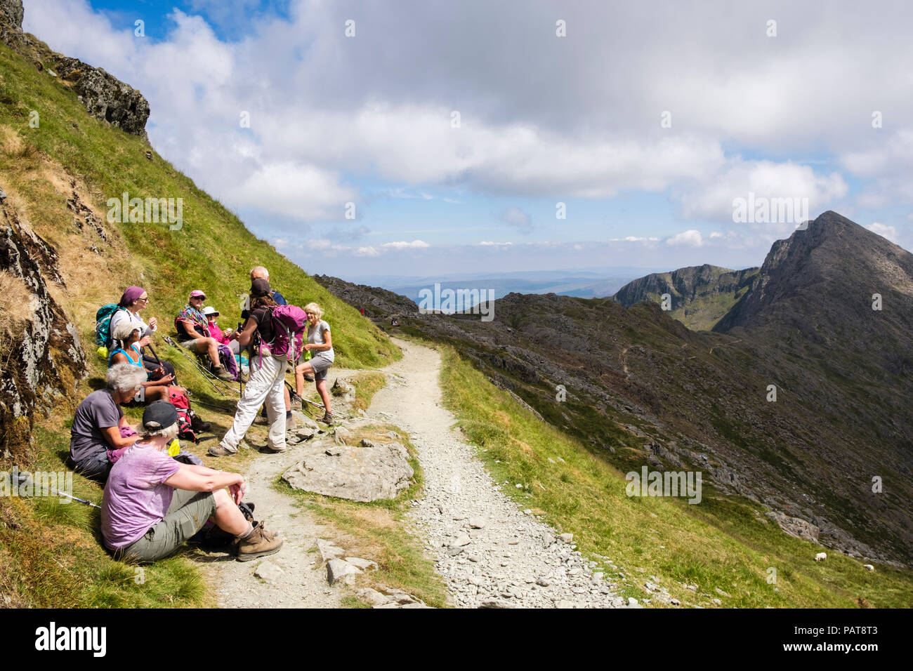Hikers resting on Watkin Path from Mount Snowdon to Y Lliwedd in mountains of Snowdonia National Park (Eryri). Cwm Llan, Gwynedd, Wales, UK, Britain Stock Photo