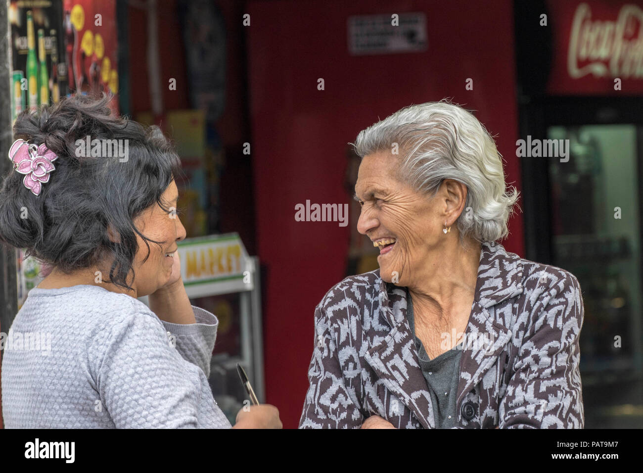 Two elderly women laughing and talking in Ecuador Stock Photo