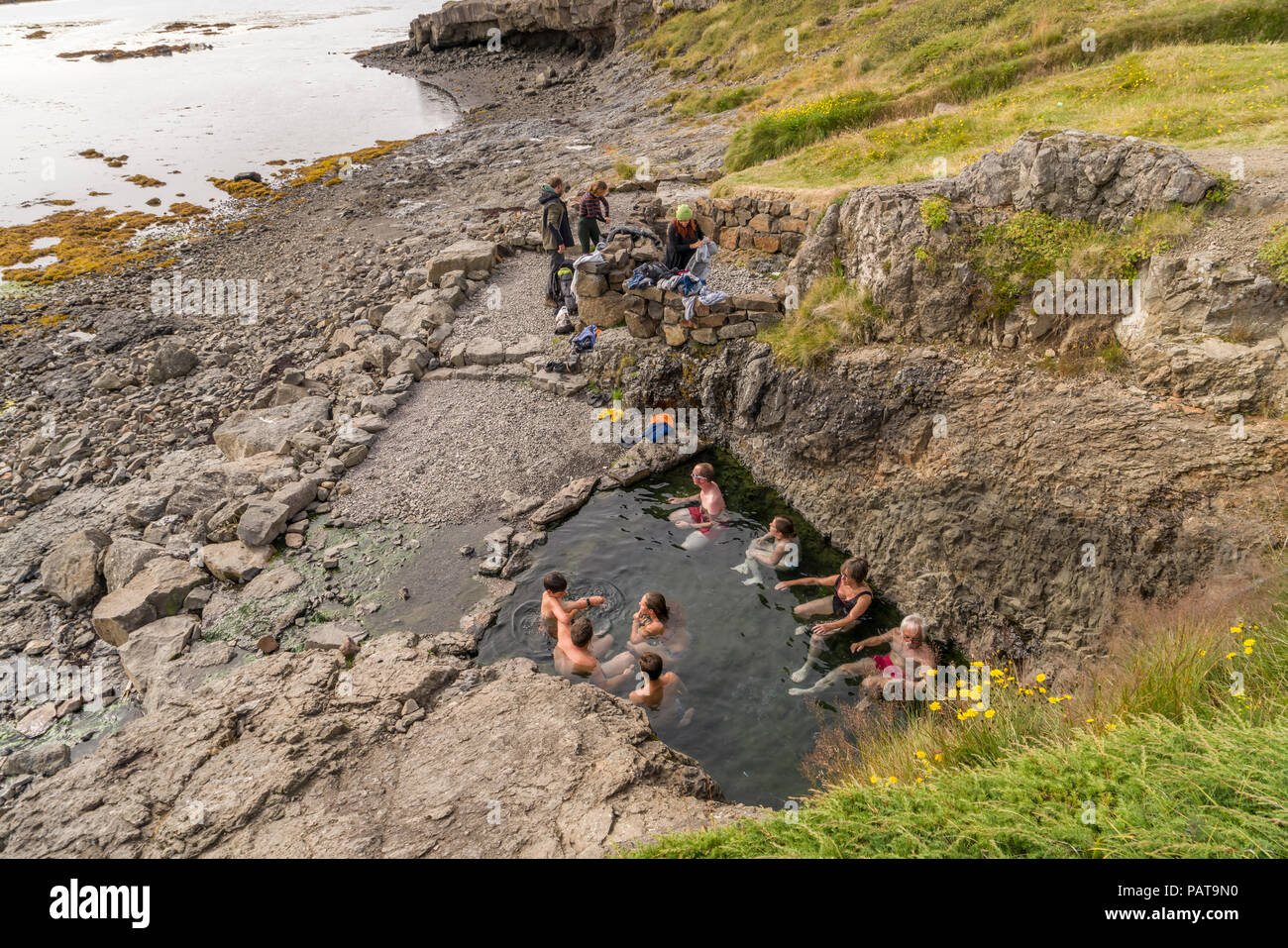 People enjoying a natural hot spring, Flokalundur, West Fjords, Iceland Stock Photo
