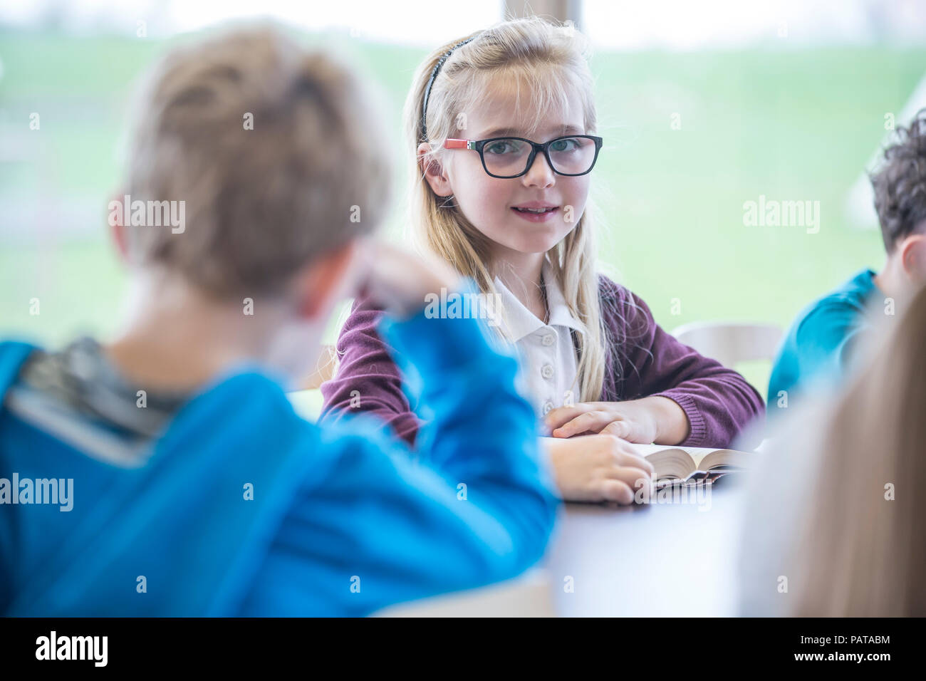 Portrait of smiling schoolgirl with classmates in class Stock Photo - Alamy
