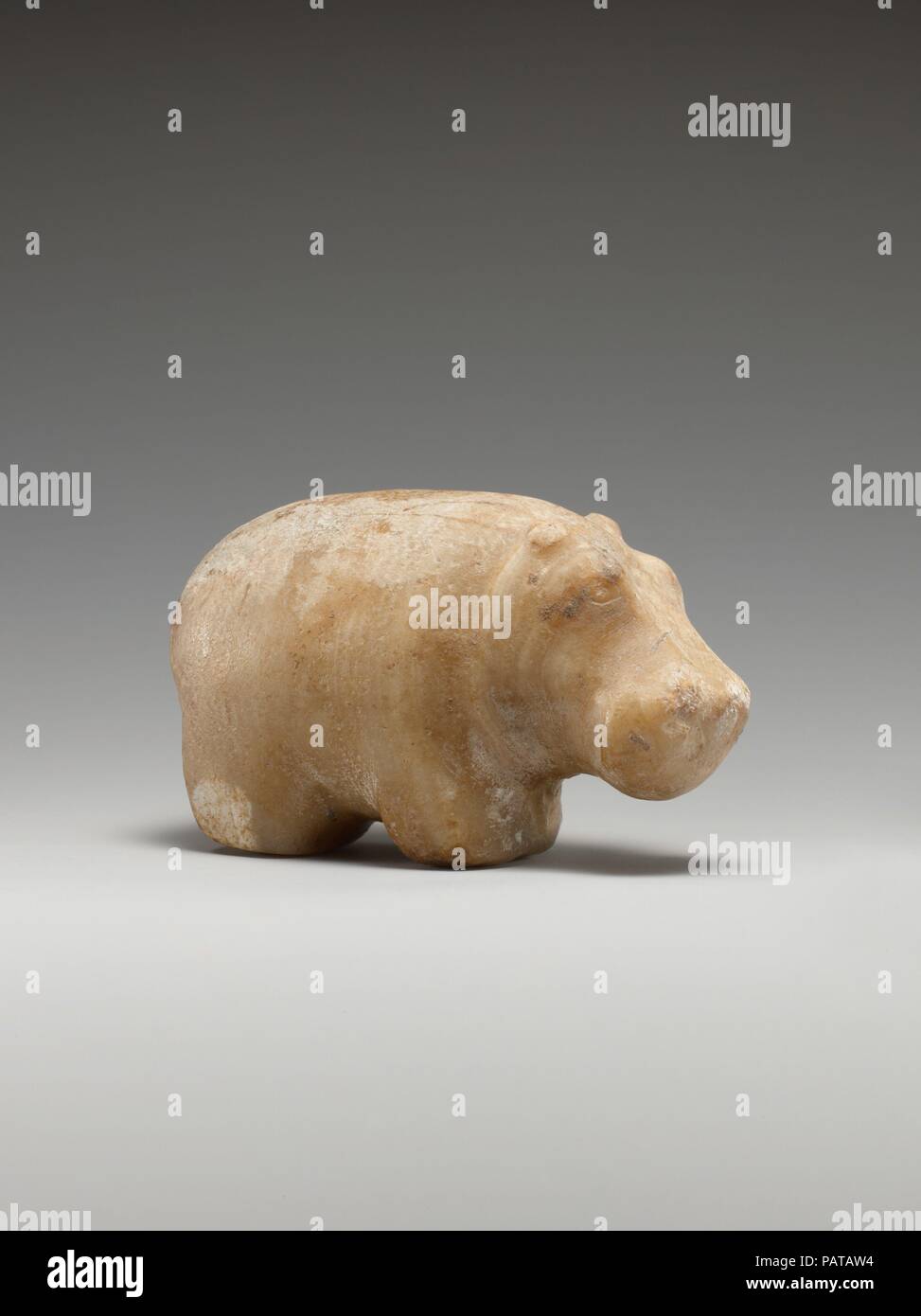 Small statuette of a hippopotamus. Dimensions: L. 8.8 cm (3 7/16 in.); H. 5.3 cm (2 1/16 in.). Date: ca. 3100-2649 B.C..  Excavated from a deposit near an early shrine, this figurine of a hippo was most likely a gift to Khentiamentiu, the funerary deity who preceded Osiris at the Abydos temple. The hippo's form is skillfully modeled, employing only a few, well-placed details to convey succinctly the animal's identity.  Throughout the Predynastic Period (ca. 4400-3100 B.C.), representations of hippos were placed in tombs and other ritual contexts. This animal was feared and as a result became t Stock Photo