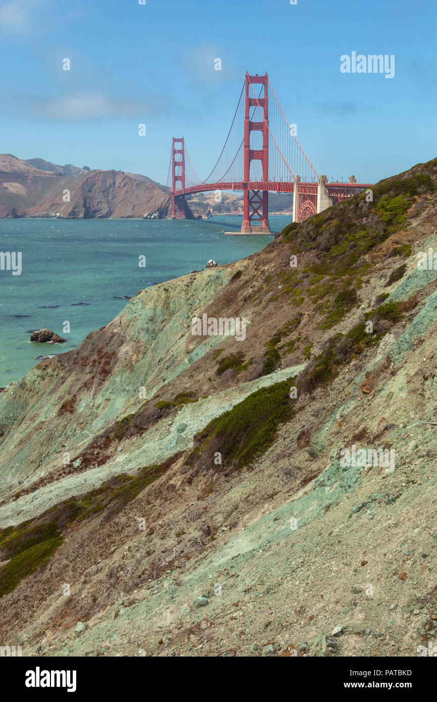 Unique bluish-green serpentinite at Marshall Beach, with the Golden Gate Bridge in background, San Francisco, California, United States. Stock Photo