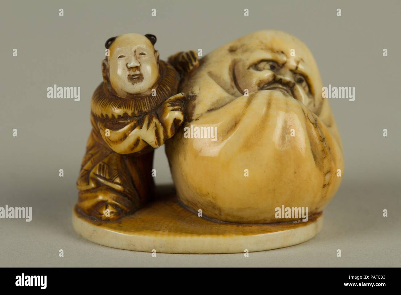 Netsuke of Dharma with a Small Boy. Culture: Japan. Dimensions: H. 1 1/8 in. (2.9 cm); W. 1 3/8 in. (3.5 cm); D. 1 in. (2.5 cm). Date: 19th century. Museum: Metropolitan Museum of Art, New York, USA. Stock Photo