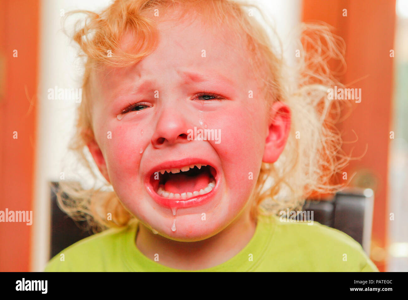 Crying child with curly red hair Stock Photo