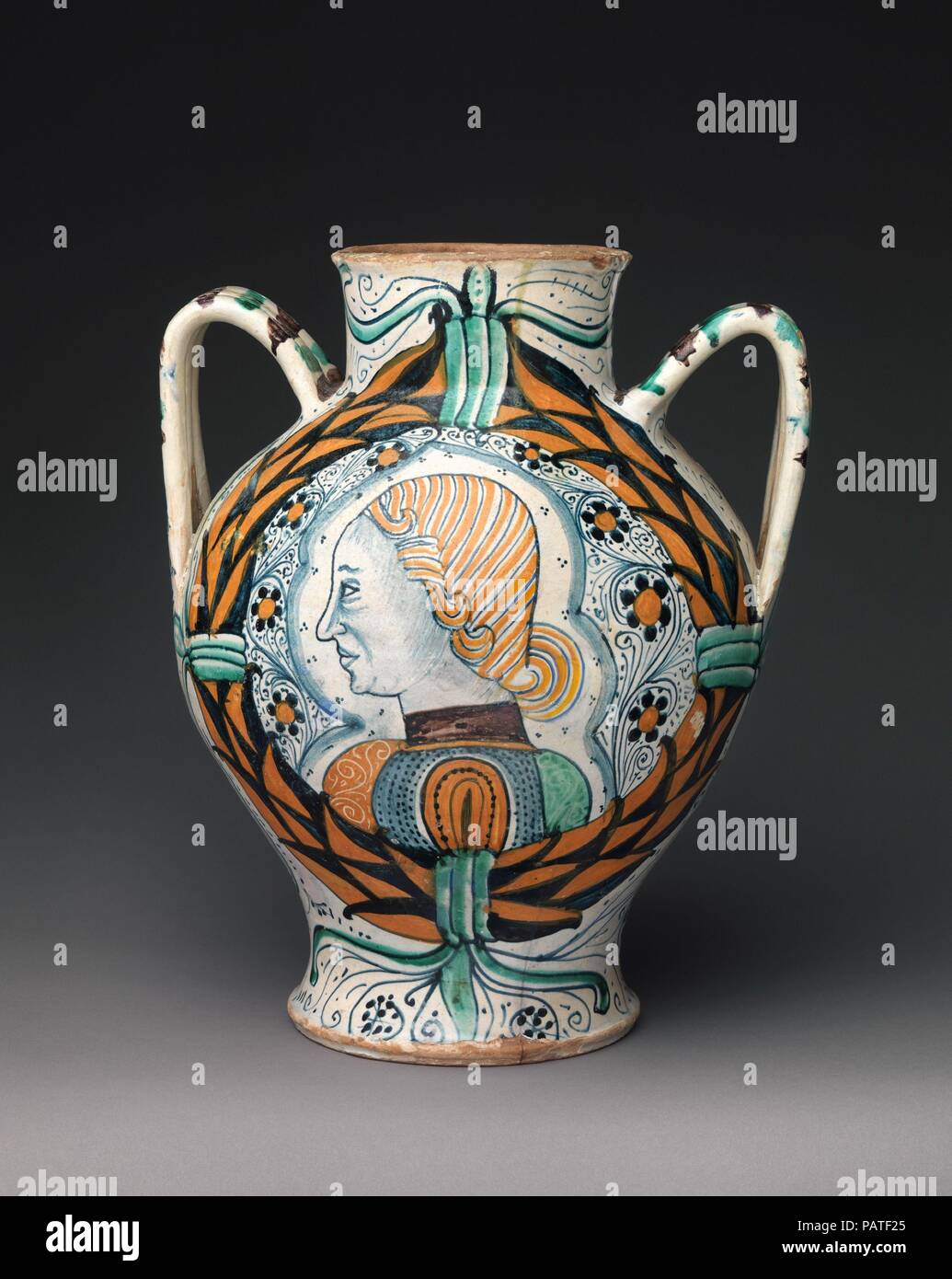 Two-handled pharmacy or storage jar with arms of the Orsini family and profile head of a man. Culture: Italian, probably Deruta. Dimensions: Overall (confirmed): 14 × 11 1/2 × 10 5/8 in. (35.6 × 29.2 × 27 cm). Date: ca. 1460-80.  The arms of the Orsini, a powerful Roman family, appear on one side of this jar, while the profile of a young man is delicately painted on the other. Numbers scratched into the underside note its weight when empty--useful information when measuring goods. Museum: Metropolitan Museum of Art, New York, USA. Stock Photo