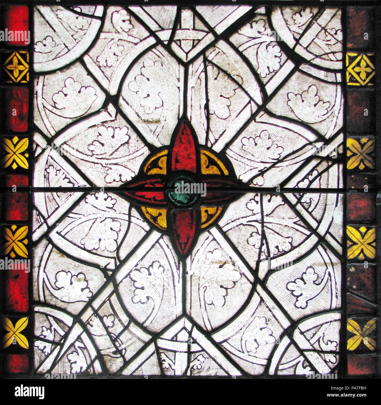 Grisaille Panel. Culture: French. Dimensions: Overall: 22 x 20 1/4in. (55.9 x 51.4cm). Date: 1270-80.  The artistry of this window derives from the contrast between the silvery effect of the grisaille decoration and the radiant colors of the bosses and borders. In addition, the graceful overlay of strapwork on spiraling vines with stylized leaves is enhanced by the bold outline of forms and the dense hatching of the backgrounds.   The windows in the choir chapel at Sées originally consisted of 'band windows,' with colored figural glass in the central zones and grisaille panels above and below. Stock Photo