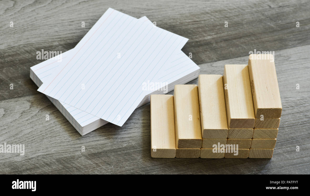 Business / Education Challenge Concept - Blank Index Cards With Stairway Upwards Of Building Blocks Over Dark Grey Wooden Background Stock Photo