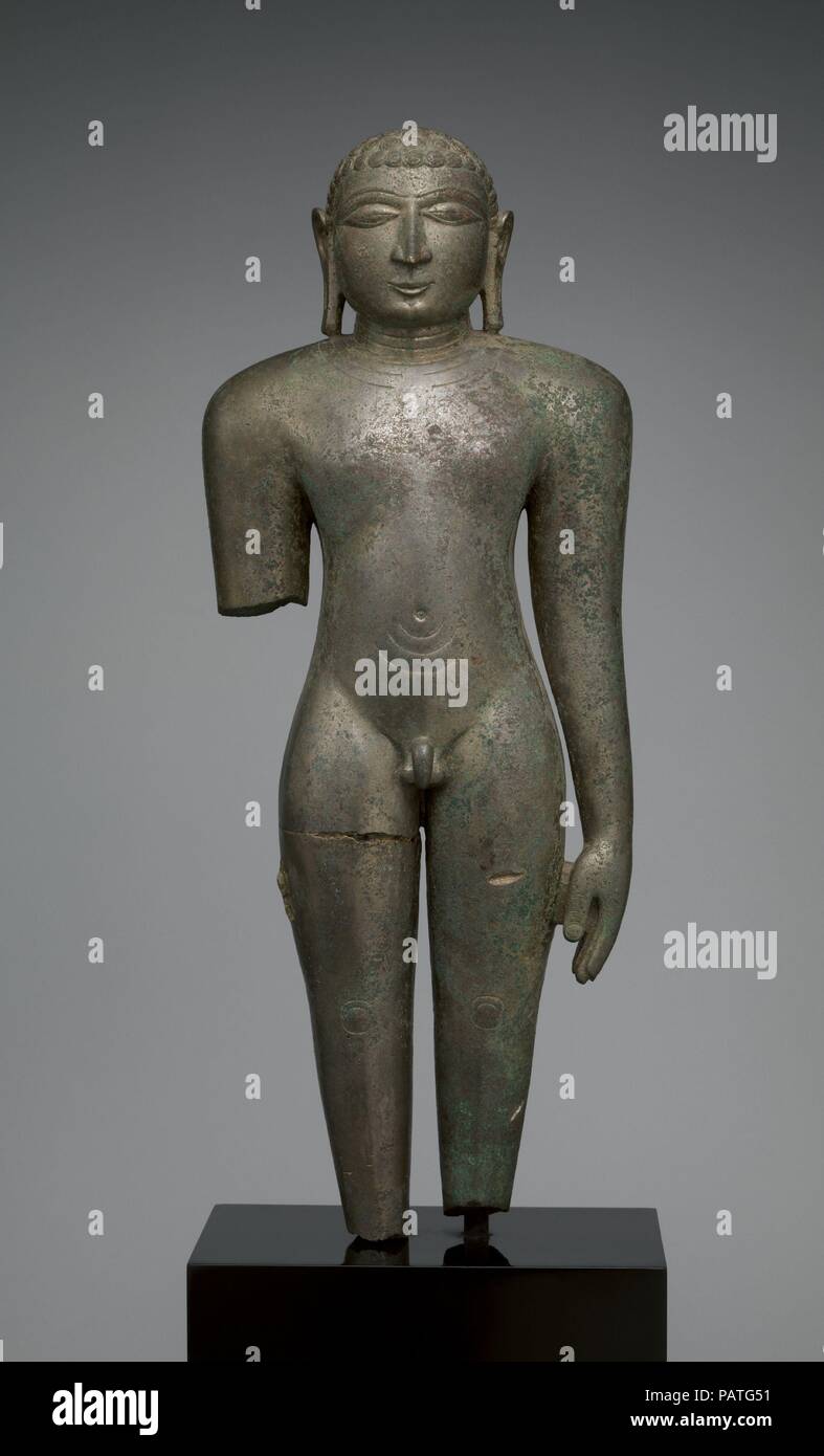 Jain Digambara Tirthanhara Standing in Kayotsarga Meditation Posture. Culture: India (Deccan, Karnataka). Dimensions: H. 22 1/2 in. (57.2 cm); W. 7 1/2 in. (19.1 cm); D. 4 in. (10.2 cm)  Base: H. 8 in. (20.3 cm); W. 9 1/2 in. (24.1 cm); D. 6 in. (15.2 cm). Date: 12th century.  A tirthankara is standing in kayotsarga, or austerity meditation. The figure is austere, completely lacking in 'adornment' (alamkara), a virtue in Hindu sculpture but seen by Digambara Jains as counter to the vows of renunciation. The short hair curls are an anomaly, as they mimic the Buddhist convention of short curls l Stock Photo