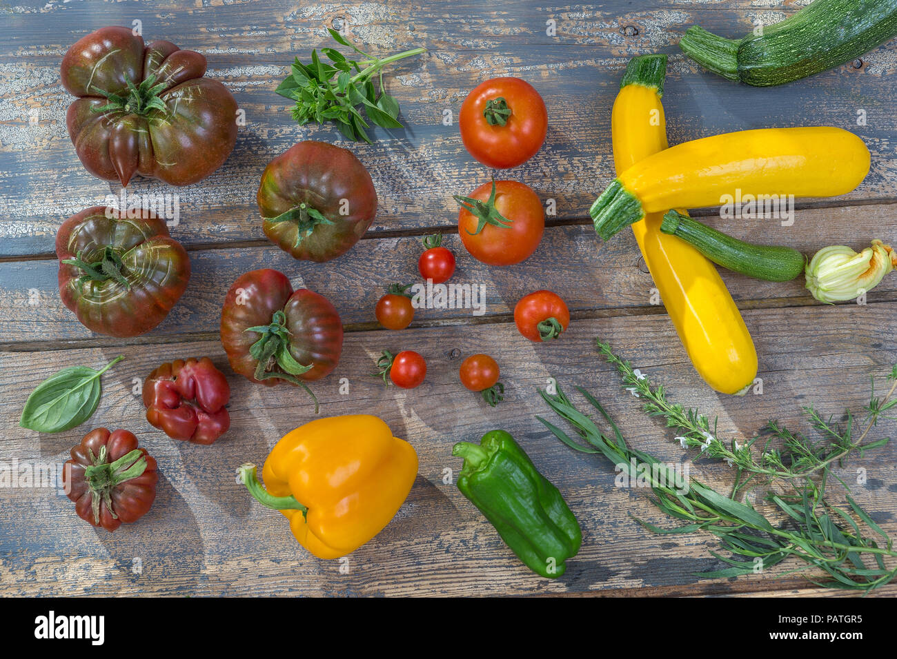 Group of Tomatoes, ancient varieties of various tomatoes on wooden boarc over a old painted wall background Stock Photo