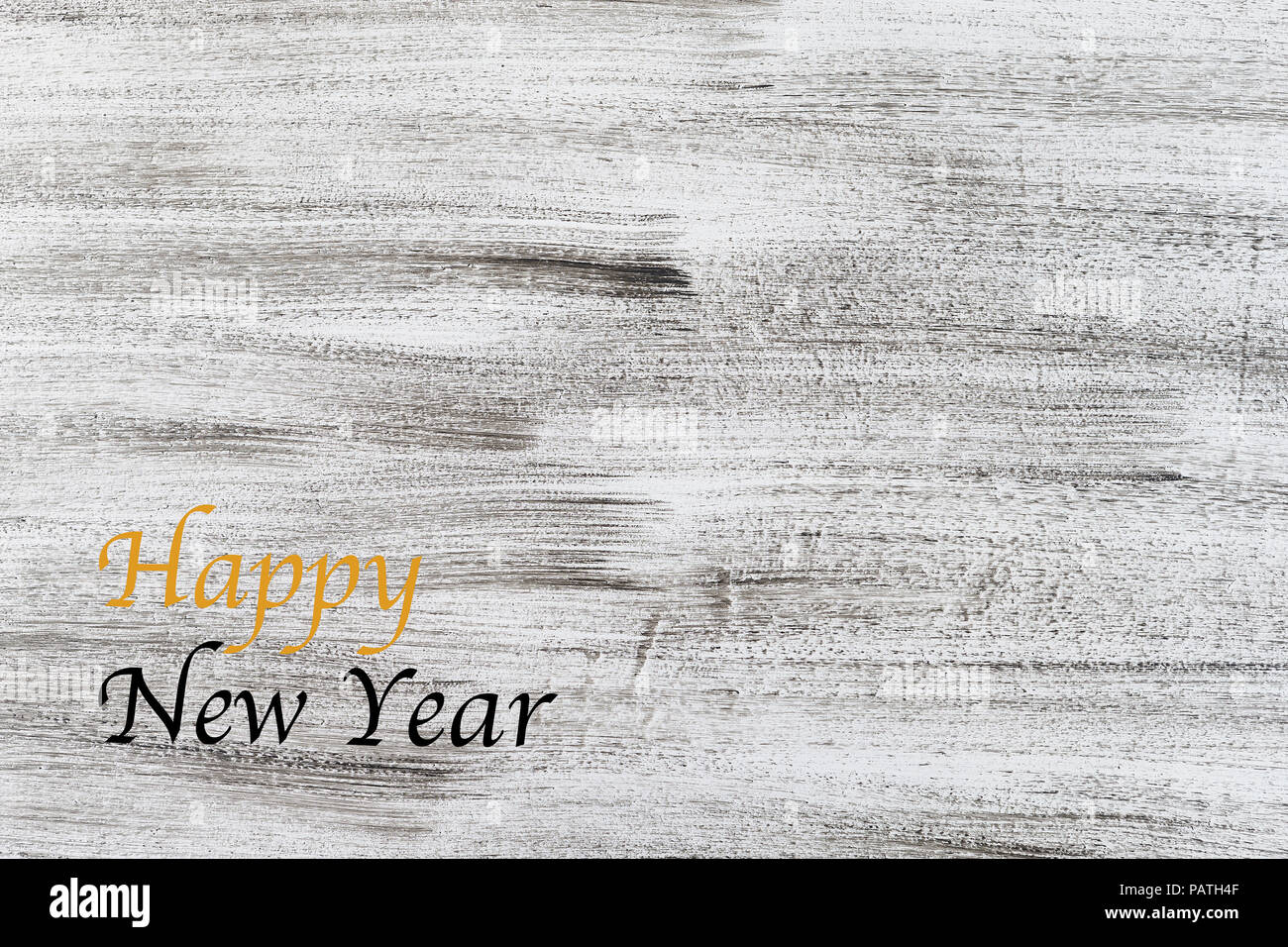 happy new year written in gold and black on antique rustic white grey wooden painted background copy space Stock Photo
