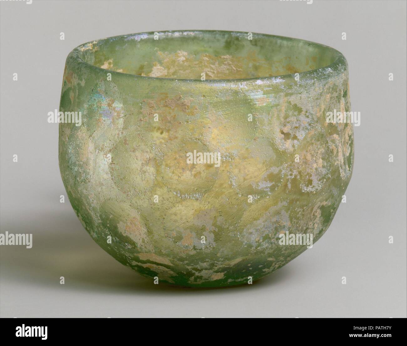 Bowl with wheel-cut facets. Culture: Sasanian. Dimensions: H. 7.9 cm. Date: ca. 6th-7th century A.D..  This hemispherical bowl may have been made by blowing molten glass into an open mold (though possibly it was free-blown); subsequently, four rows of oblong-to-round facets were wheel-cut and polished. The thick glass, originally pale green, has lost much of its surface color and gained extensive iridescence through weathering.  Faceted bowls such as this one are characterized by uniformity of shape, size, and arrangement of the facets in four or five rows. They represent the most widespread t Stock Photo