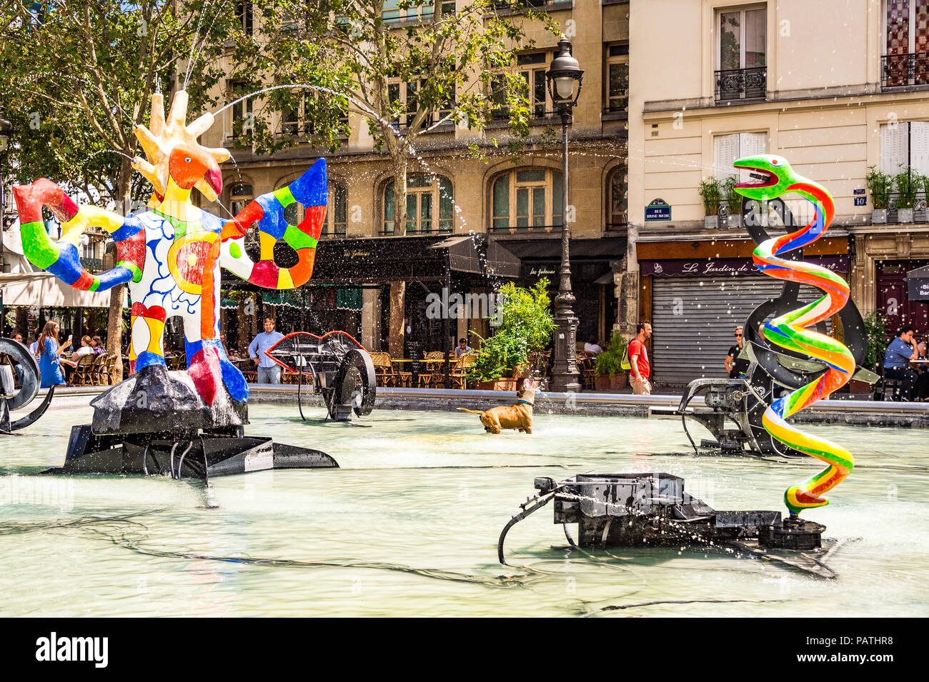 A dog plays in the Stravinsky Fountain, next to the Centre Pompidou