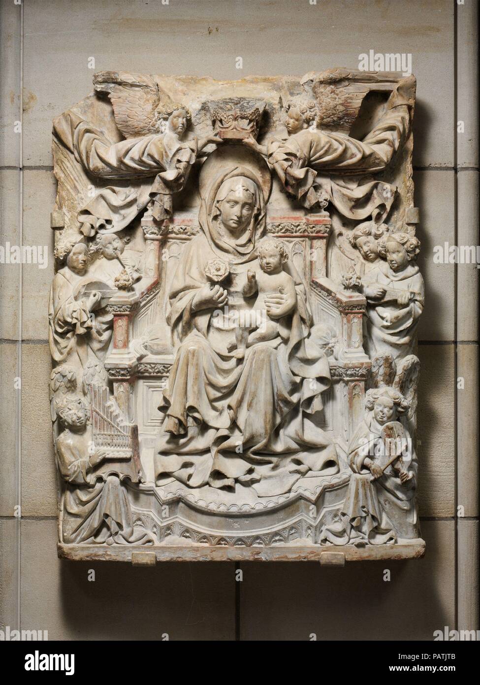 Relief with Enthroned Virgin and Child surrounded by Angels. Culture: North Italian. Dimensions: Overall: 32 1/4 x 23 3/4 x 5 7/8 in. (81.9 x 60.3 x 14.9 cm). Date: ca. 1425-40.  Musical angels herald the heavenly coronation of the Virgin in this elegant and refined carving. Its original context is uncertain, but it was possibly made as an independent devotional image or as part of an altar decoration. Museum: Metropolitan Museum of Art, New York, USA. Stock Photo