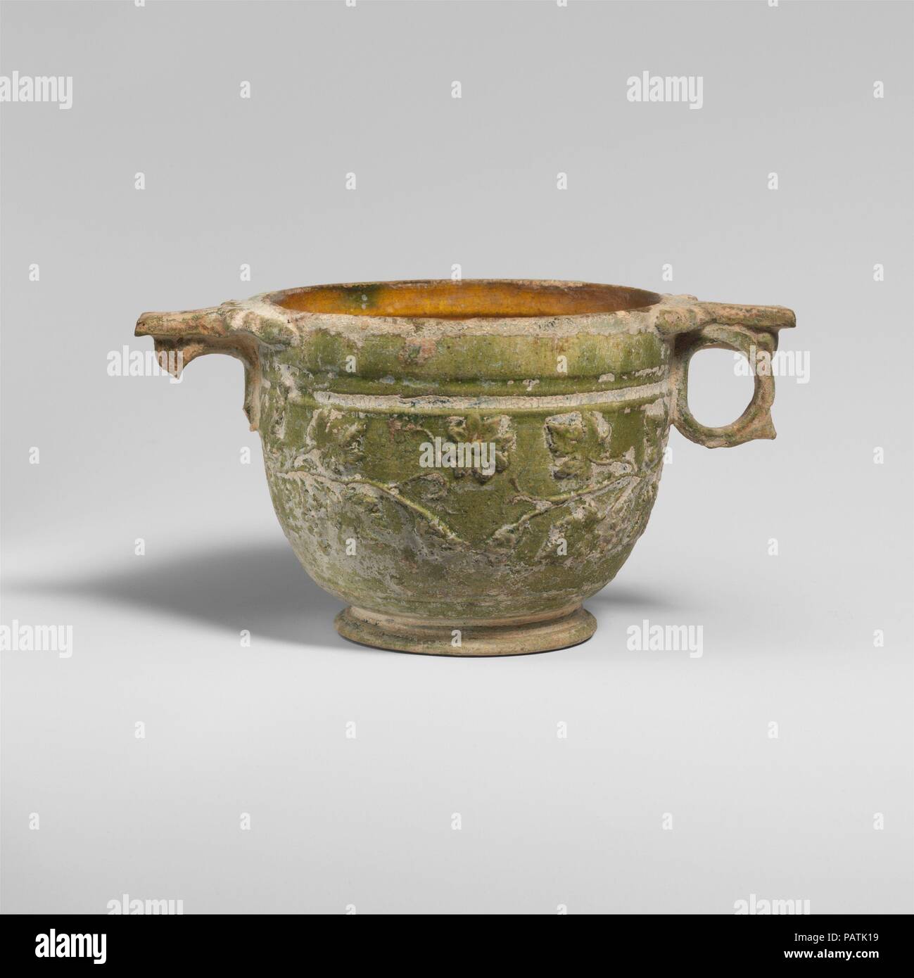 Terracotta scyphus (drinking cup). Culture: Roman. Dimensions: H. 2 15/16 in. (7.49 cm). Date: 1st half of 1st century A.D..  Green-glazed cup with floral sprays in relief. Museum: Metropolitan Museum of Art, New York, USA. Stock Photo