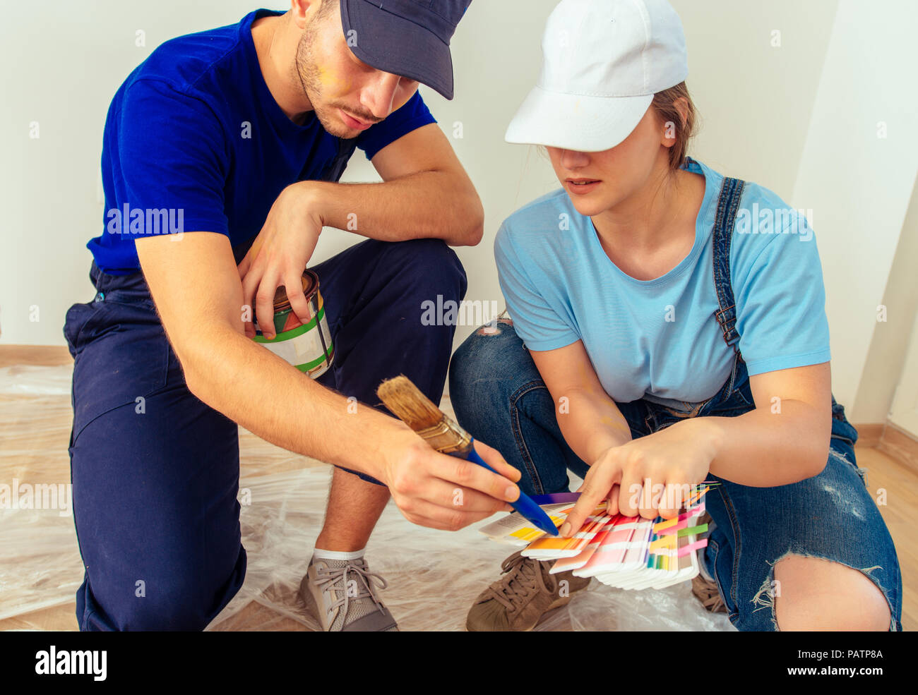 Girl in overall choosing color from palette for the walls with her ...