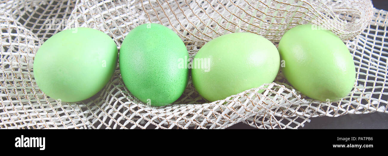 green easter eggs lie on white cloth. Stock Photo