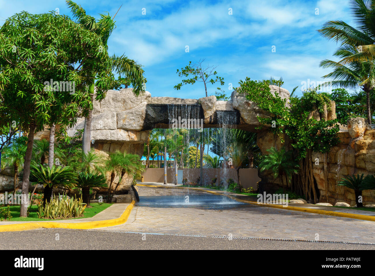 artificial waterfall above the road, interesting entrance to the park. Puerto Plata, Dominican Republic Stock Photo