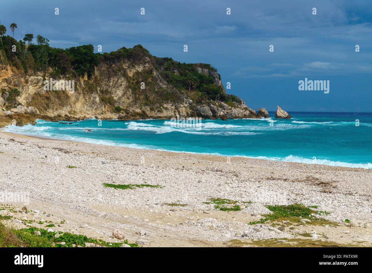 Ideal Caribbean empty beach with azure sea and green rocks in rainy weather. Perfect seascape, Dominican Republic Stock Photo