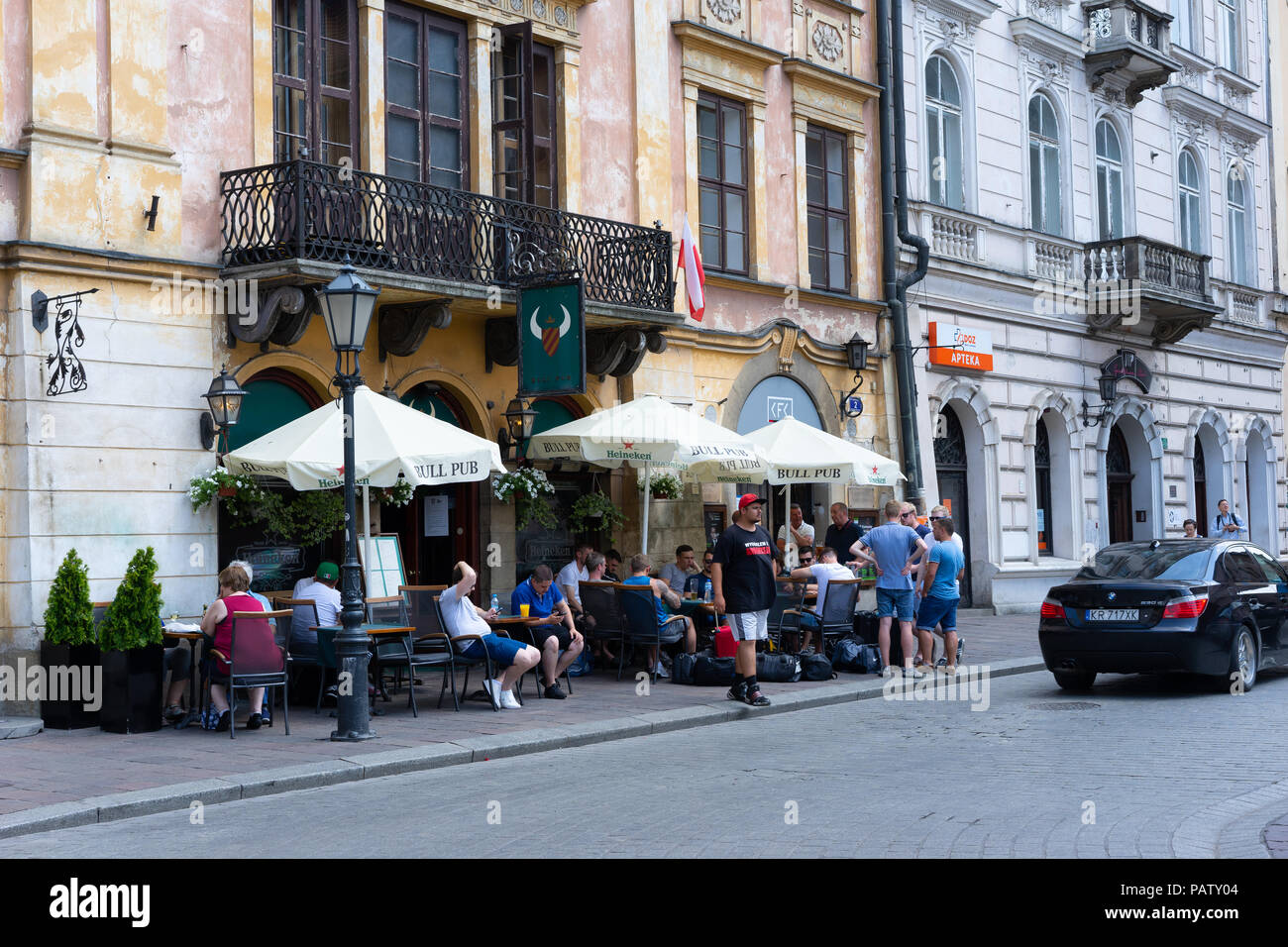 Group of young men enjoying a drink outside a pub in Krakow, Poland, Europe. Stock Photo