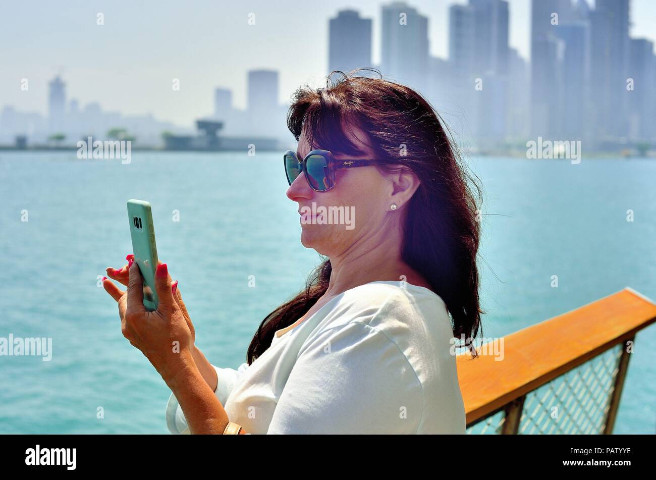 Chicago, Illinois, USA. Woman accessing her cell phone to text while at Navy Pier. Stock Photo