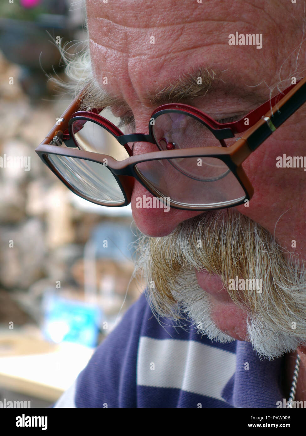 Silver haired man wearing two pairs of glasses at the same time. Property and Model released Stock Photo