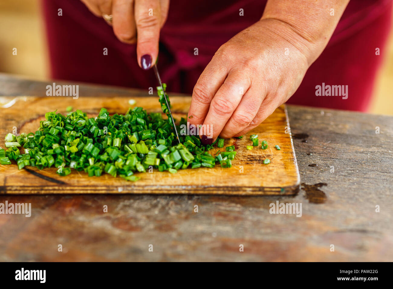 Cook Woman Cutting Green Onion On Wooden Board On Wooden Table