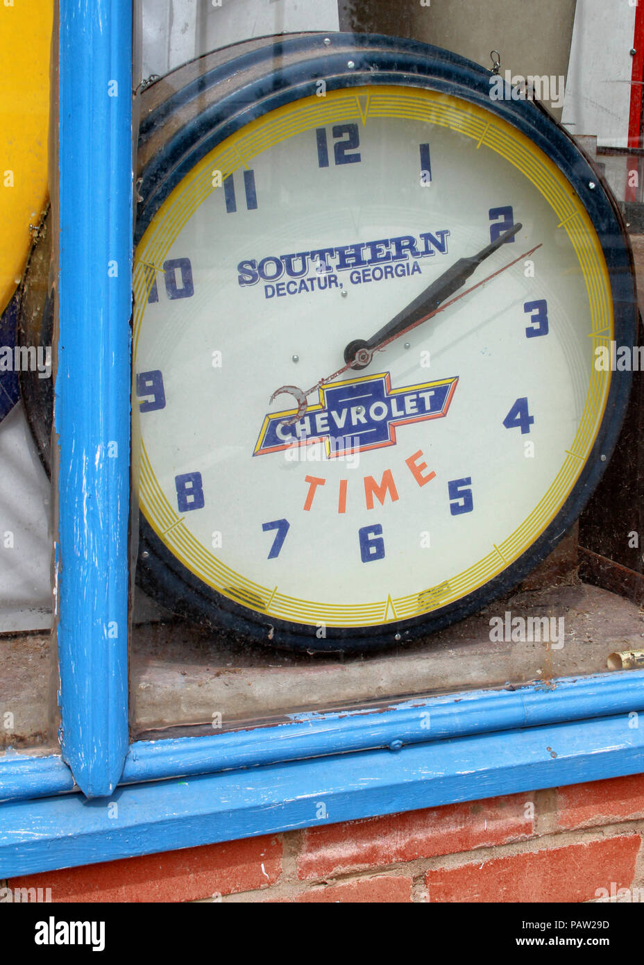 An old wall clock is on display in the window of a Main Street business in Stroud, Oklahoma. Stock Photo