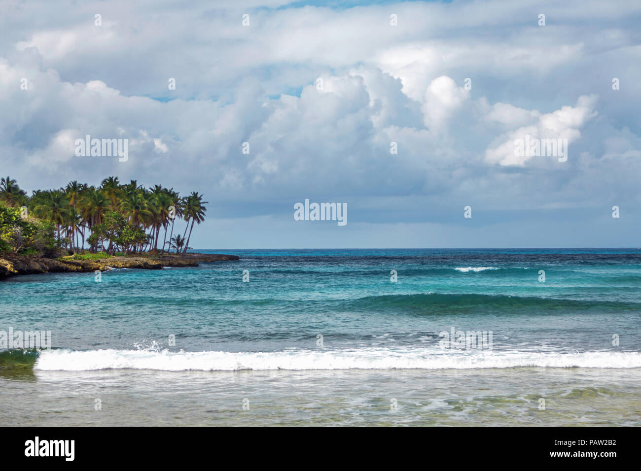 sea Bay in Samana, Dominican Republic. Sea, shore with palm trees and sky with storm clouds Stock Photo
