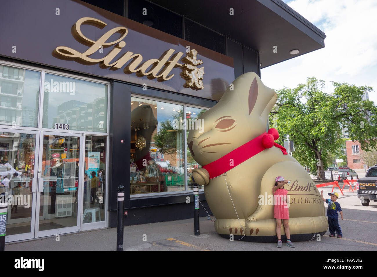 Kids pose for a photo by the giant gold Lindt Bunny inflatable outside