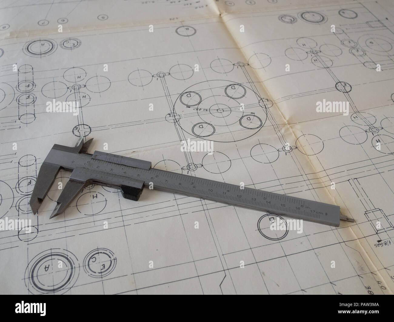 traditional vernier caliper on a vintage hand drawn technical drawing