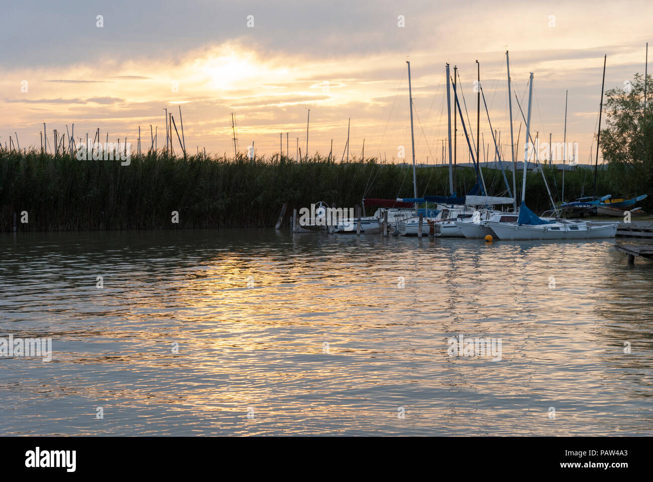 Sunset reflected in the water of Neusiedler See, a large inland lake and popular tourist destination in Burgenland, Austria Stock Photo