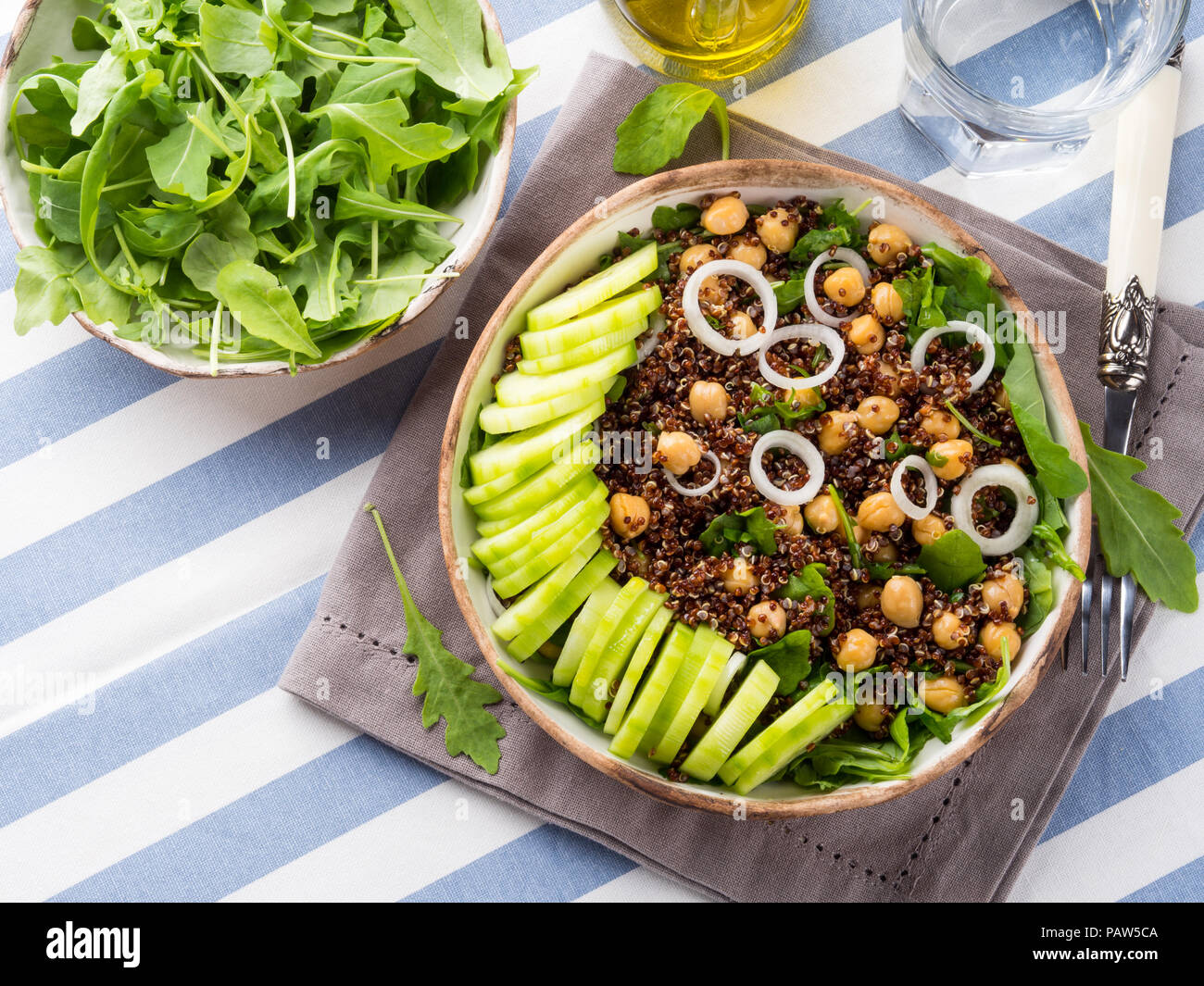 Quinoa salad bowl with cucumbers, chickpeas, onions, arugula. Light