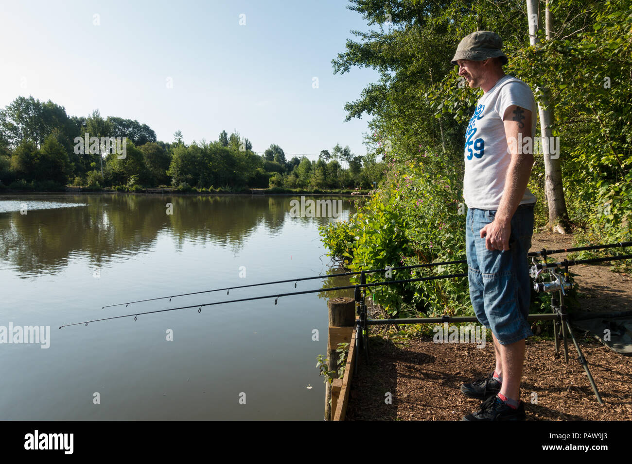 Henlow, Bedfordshire, UK, 25th July 2018. Angler James  set up very early before the heat becomes too much for him Stock Photo